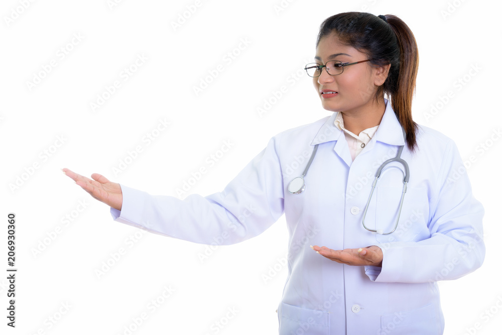 Studio shot of young happy fat Persian woman doctor smiling whil Studio shot of young happy fat Persian woman doctor smiling whil