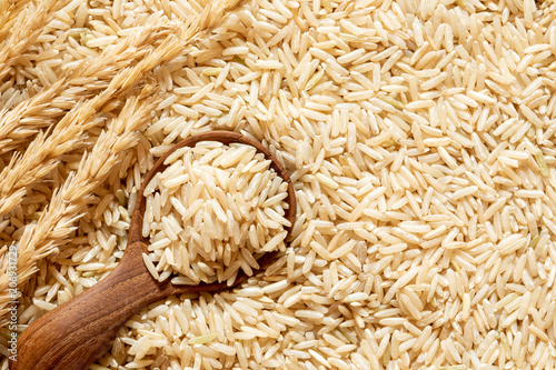 Obraz na płótnie Brown rice in a wooden spoon on rice seed background
