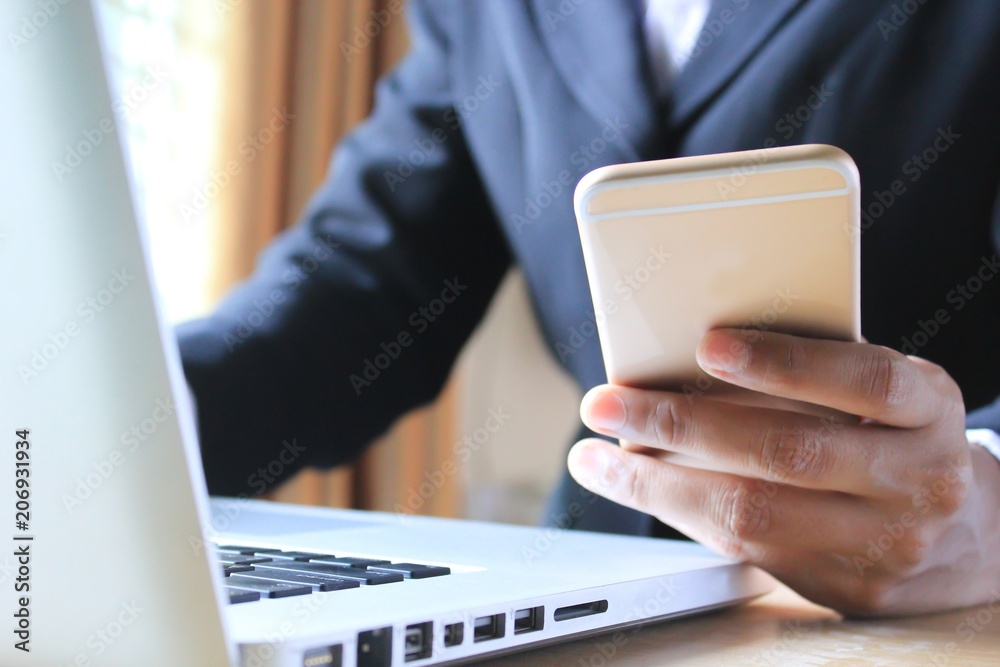 Businessman using smartphone and laptop in the office. Businessman using smartphone and laptop in the office.