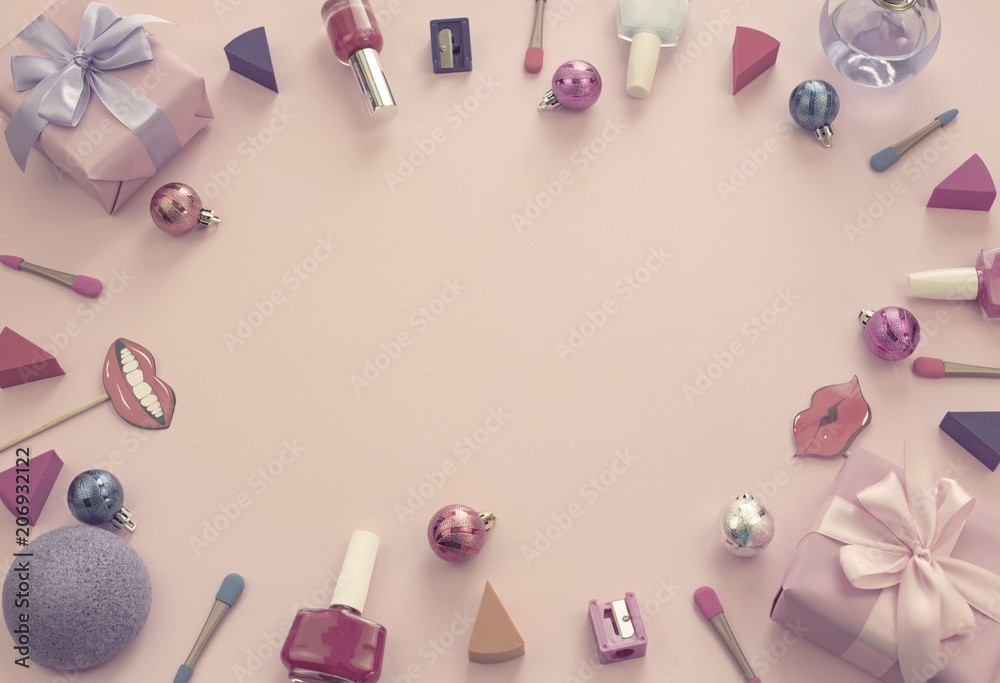 composition set of decorative cosmetics nail Polish lipstick sponge sharpener box gift ribbon satin bow background pink.
