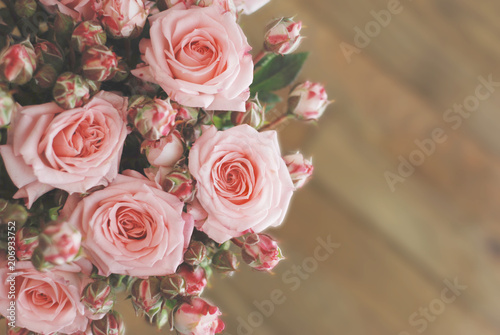 Pink Beautiful Roses Bouquet over Wooden Table. Top view Copy Space. Vintage Greeting Card