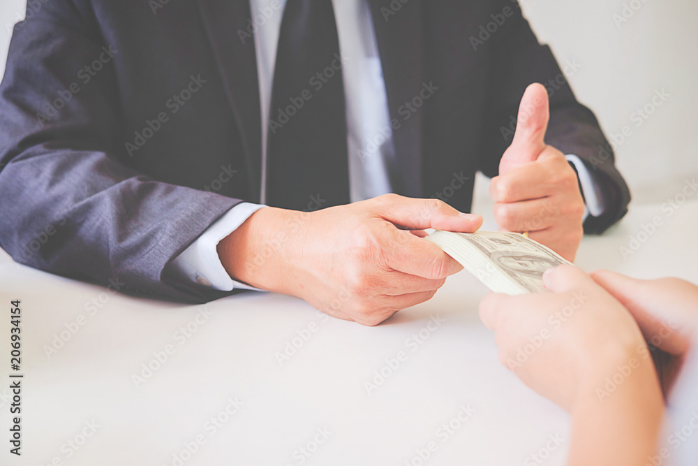 Lawyer businessman in suit hides money. A bribe in the form of dollar bills.