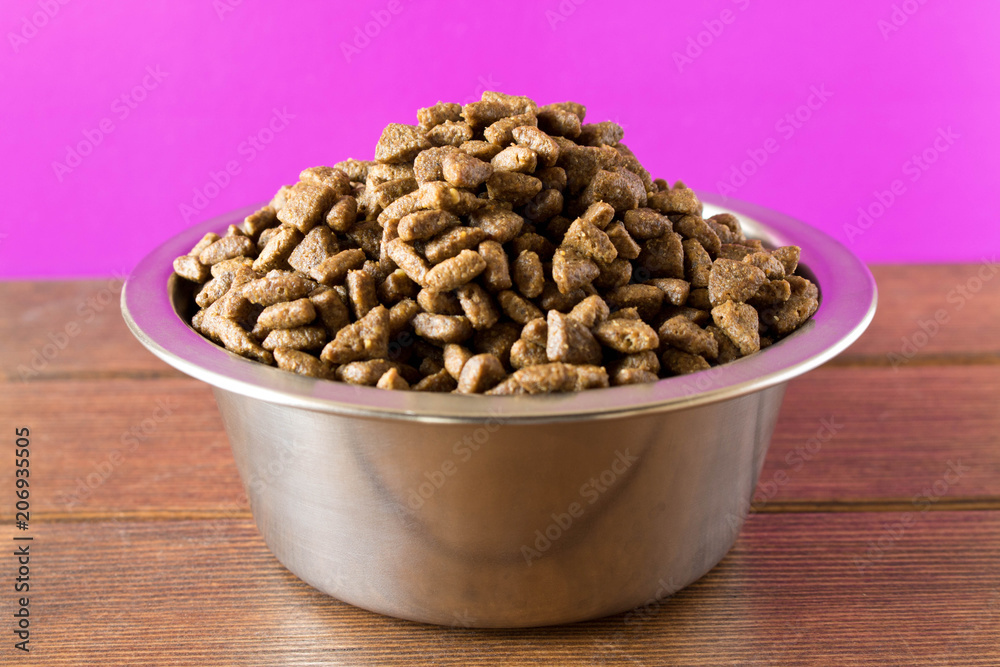 Bowl with dog food on a wooden table Bowl with dog food on a wooden table