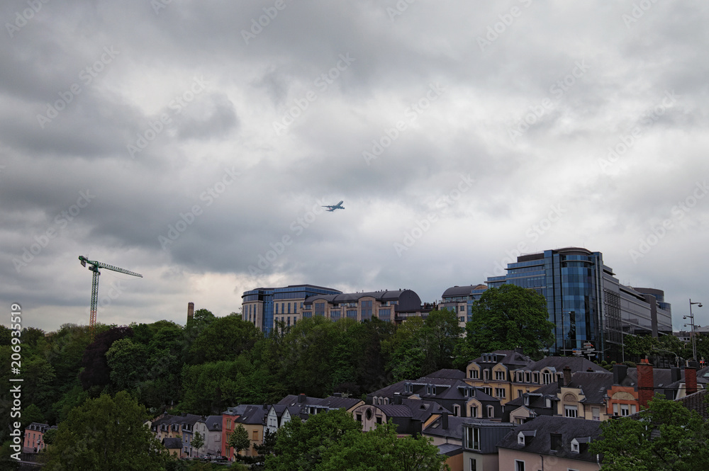 Cloudy spring morning in Luxembourg City. Downtown city, scenic view to the park and buildings. the plane is flying over the residential area of Luxembourg, Grand Duchy of Luxembourg