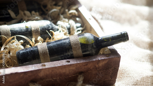 old bottles of wine in wood shaving photo