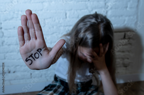 Pretty young girl showing the word stop written on her hand. Violence,abuse and bullying concept