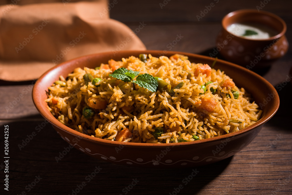Indian Vegetable Pulav or Biryani made using Basmati Rice, served in terracotta bowl. selective focus Indian Vegetable Pulav or Biryani made using Basmati Rice, served in terracotta bowl. selective focus