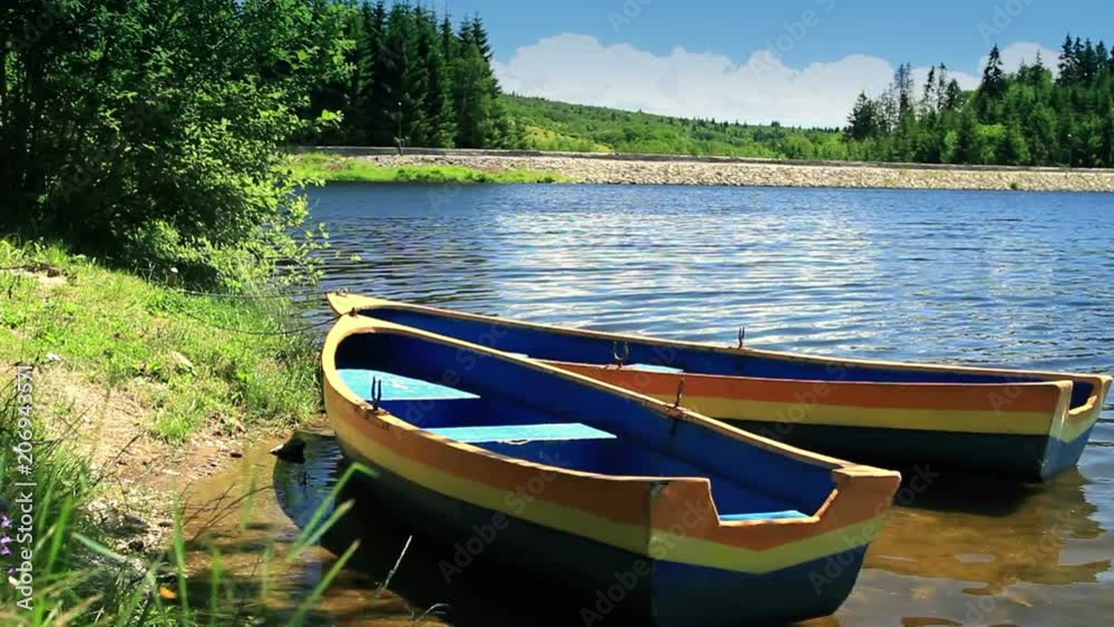 Row Boat moored near shore. Ripple lake water. Boat rental business. Row Boat moored near shore. Ripple lake water. Boat rental business.