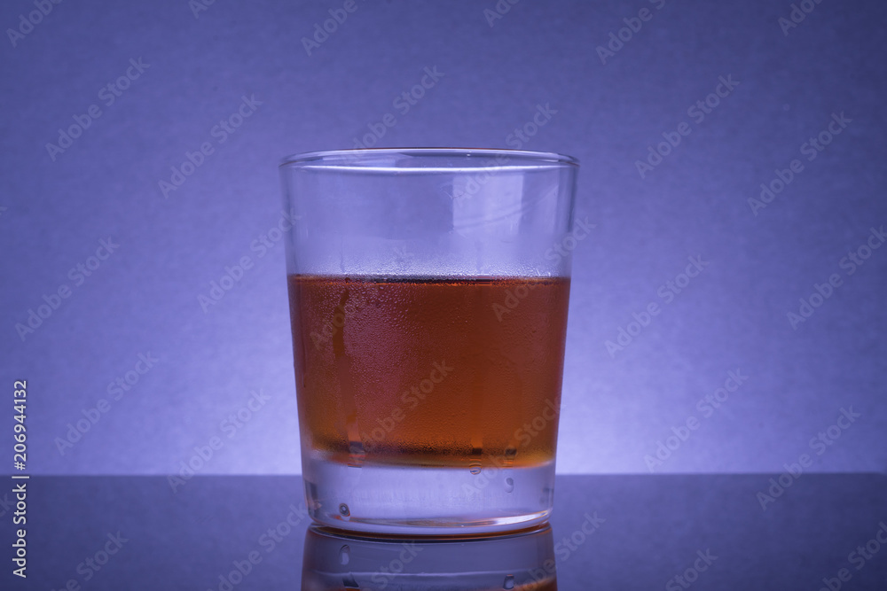 Alcoholic drink or liquor in a transparent glass mug studio shot. Alcoholic drink or liquor in a transparent glass mug studio shot.