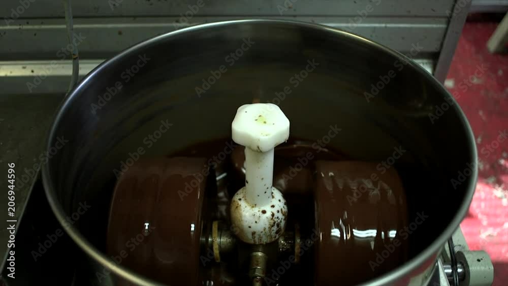 Chocolate machine open while spinning and grinding chocolate. Chocolate machine open while spinning and grinding chocolate.