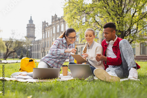 First year. First year students feeling curious while looking at their university schedule sitting outside