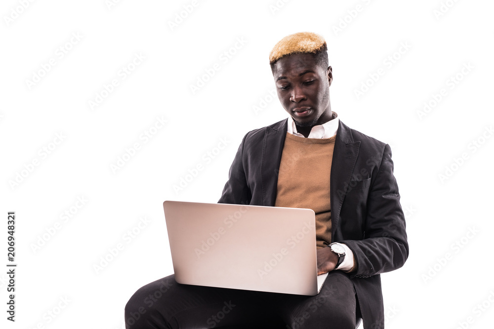 Portrait of confident afro business man dressed in classic elegant suit using laptop for work isolated on gray background Portrait of confident afro business man dressed in classic elegant suit using laptop for work isolated on gray background