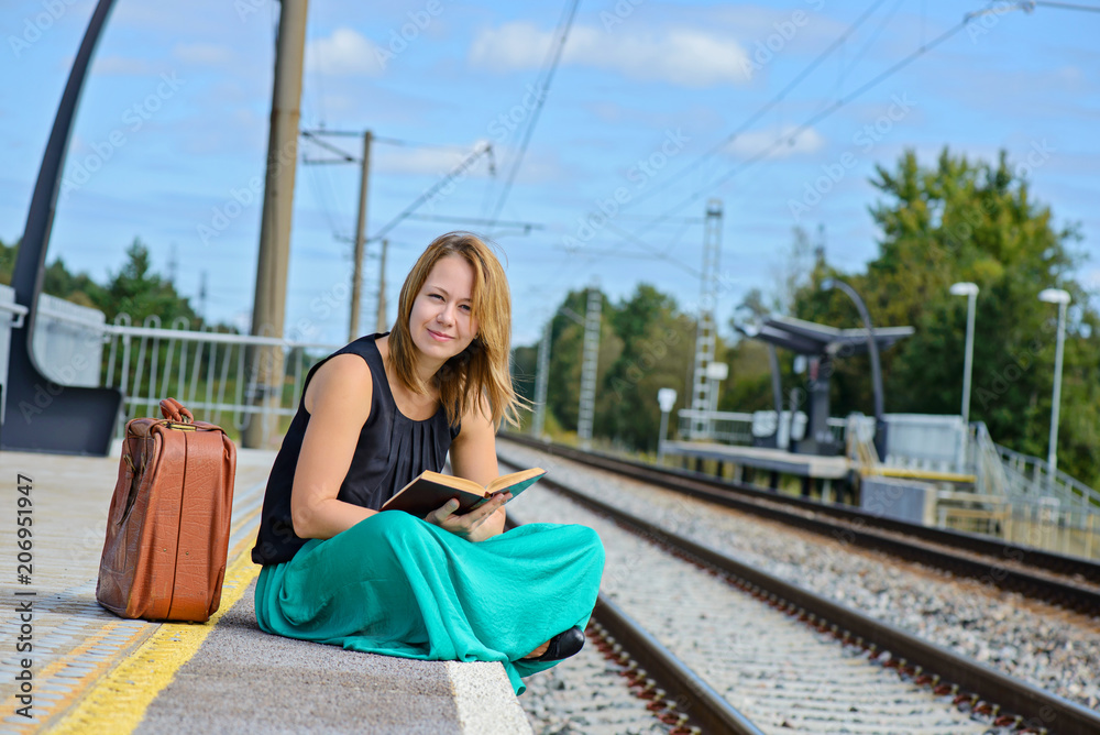 Woman sitting on the station and reading