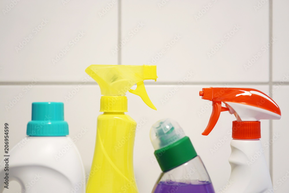 various cleaning products and detergent in front of white bathroom tiles with copy space various cleaning products and detergent in front of white bathroom tiles with copy space