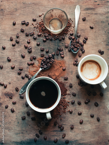 Different kinds of coffee. Full mug, drunk coffee from cup and glass with spoons (wooden background) 
