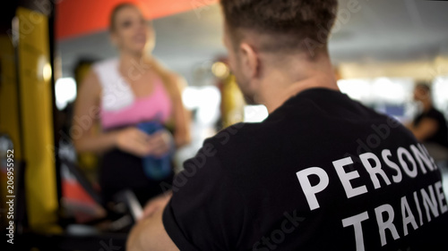 Fotografia, Obraz Personal trainer talking to female gym client after workout, sport club service