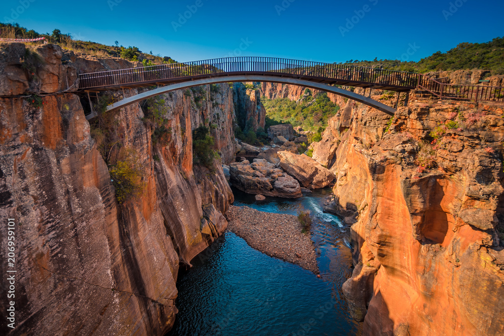 A wide shot of the river gorge and a high bridge at Bourke’s Luck Potholes in Mpumalanga, South Africa; a geological formation carved out by the movement of water