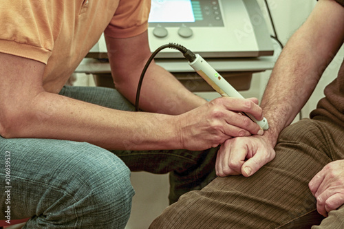 Physiotherapist treating male arm photo