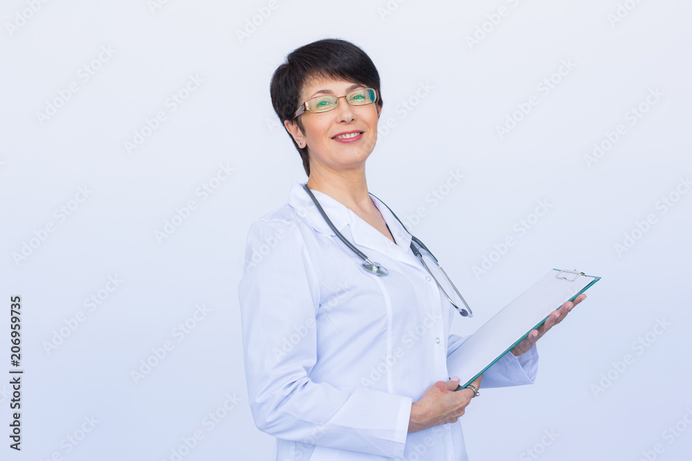 Portrait Of Female Doctor Writing On Clipboard Over a white background Portrait Of Female Doctor Writing On Clipboard Over a white background