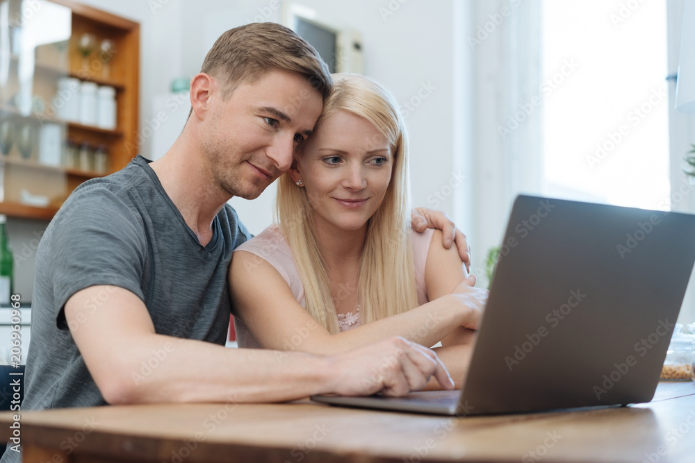 Young couple browsing the web on a laptop Young couple browsing the web on a laptop
