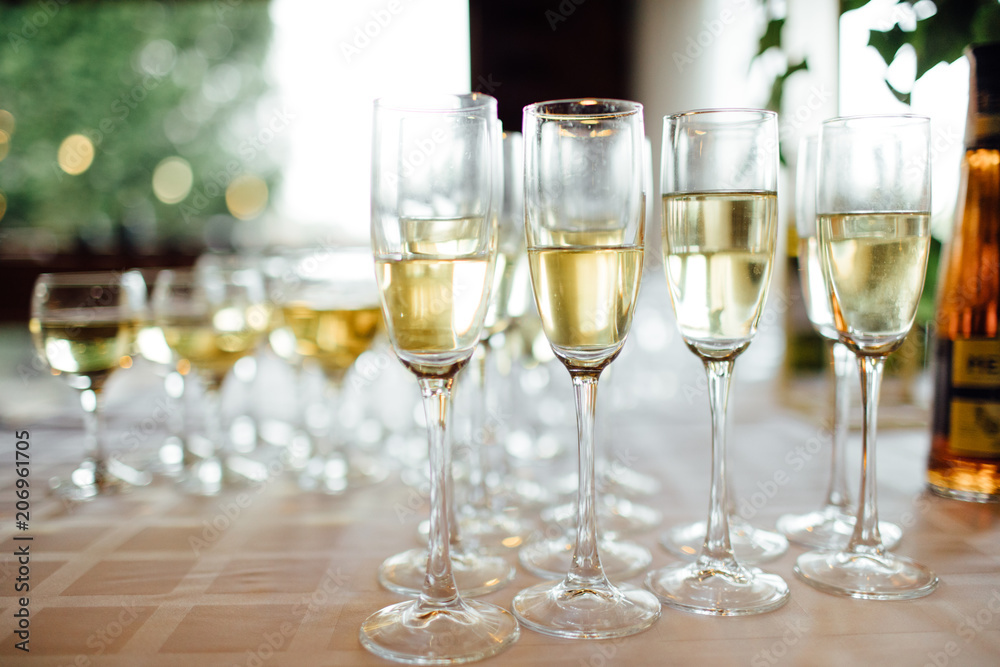 A lot of wine glasses with a cool delicious champagne or white wine at the bar. Alcohol background. A lot of wine glasses with a cool delicious champagne or white wine at the bar. Alcohol background.