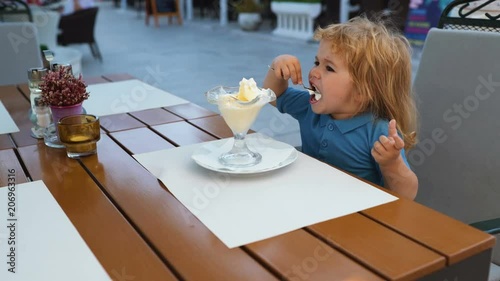 Child Childhood Children Happiness Concept. Sweet toddler boy eating ice cream. Kids enyoj happy day. Happy kid having fun. photo