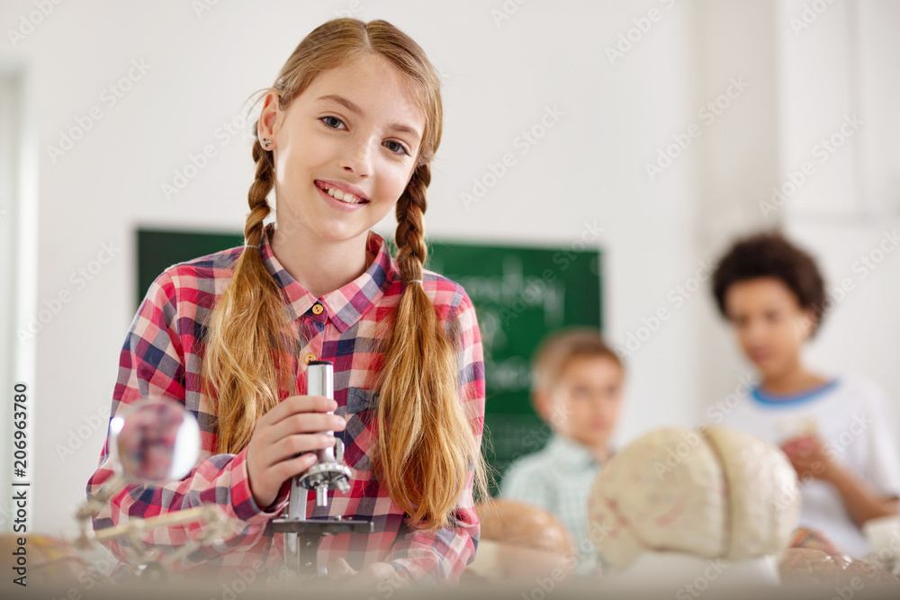Positive mood. Cheerful happy girl smiling to you while enjoying her biology lesson Positive mood. Cheerful happy girl smiling to you while enjoying her biology lesson