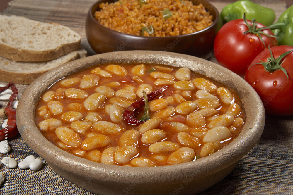 Dried beans,white beans in tomato sauce in bowl closeup. horizontal
