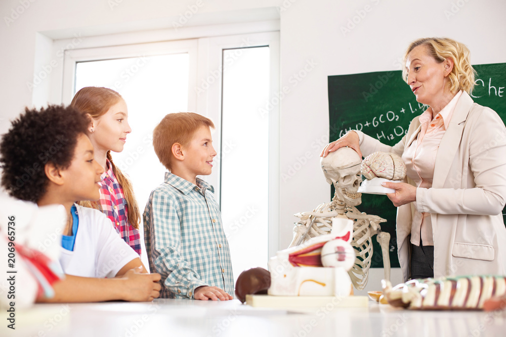 School education. Smart nice woman telling about human brain while working as a biology teacher at school School education. Smart nice woman telling about human brain while working as a biology teacher at school