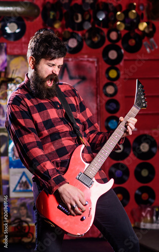 Rock star concept. Musician with beard play electric guitar.