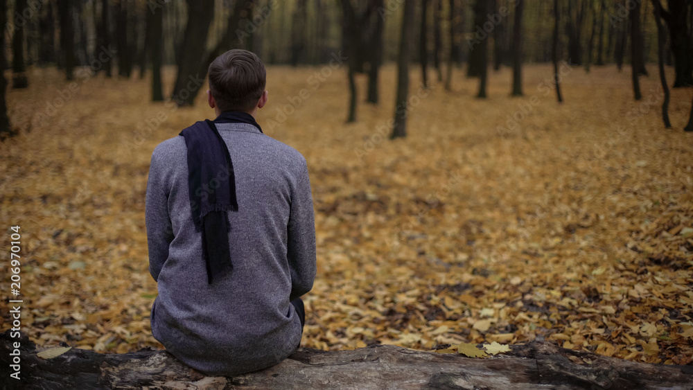 Man sitting in park alone, gray tones express depression, sadness, melancholy Man sitting in park alone, gray tones express depression, sadness, melancholy