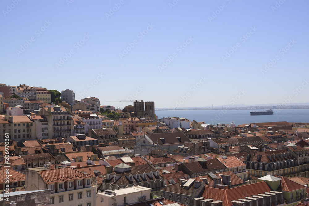 The view of the city from view point. The roofs of the houses and the river. Lisbon, Portugal.