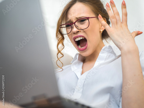 aggressive career woman. Screaming and frustrated woman with laptop photo