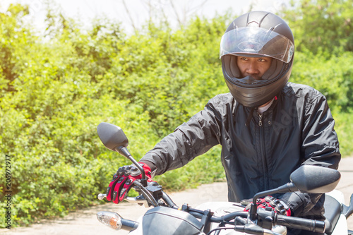 Man in a Motorcycle with helmet and gloves is an important protective clothing for motorcycling throttle control,safety concept © saelim