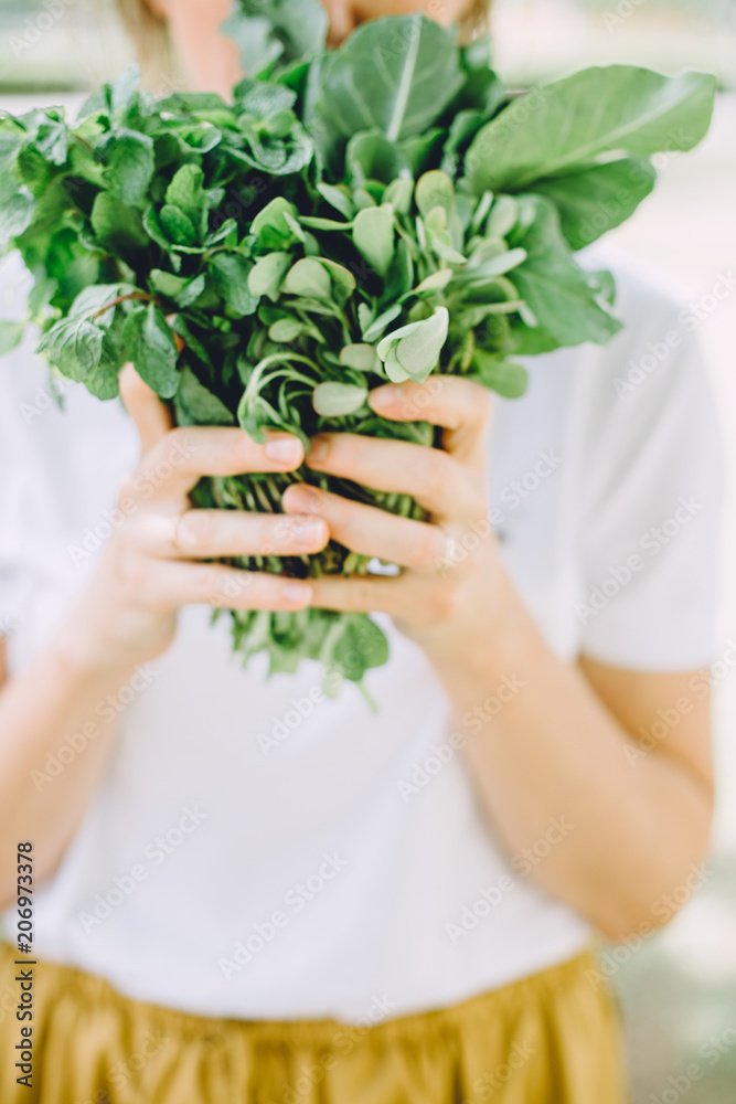 Young woman relaxing at summer picnic holding herbs