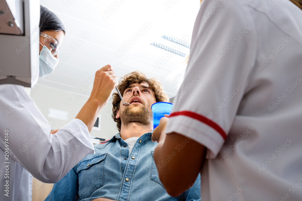A female Dentist preparing to examine a Patient A female Dentist preparing to examine a Patient