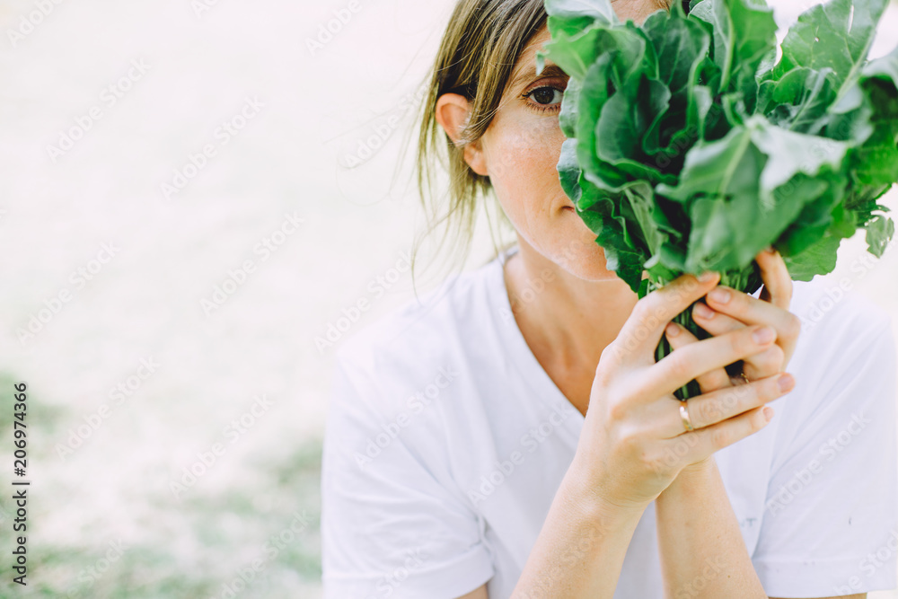 Young woman relaxing at summer picnic holding herbs Young woman relaxing at summer picnic holding herbs