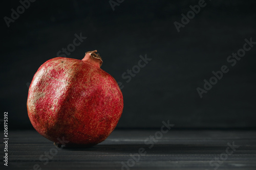 Pomegranate fruit on black wooden background