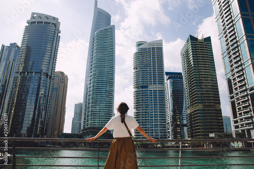 Photography Female traveler looking at modern city architecture against blue sky, Dubai, UAE