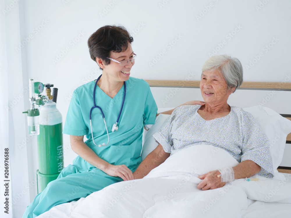 Obraz premium Nurse take care elderly woman in hospital room.