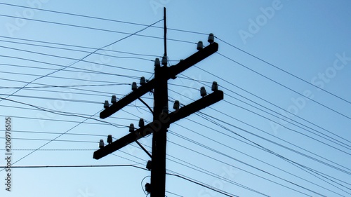 old wooden electric pole with linear insulators and electrical wires. 