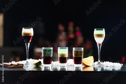Three shots in glasses b-52 and two shots in glasses on the bar table.