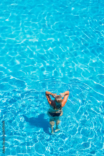 woman relaxing in infinity pool at luxury resort spa retreat.