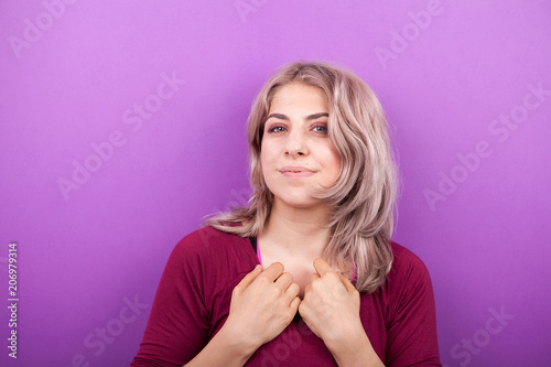 Happy smiling young blonde woman portrait on purple background