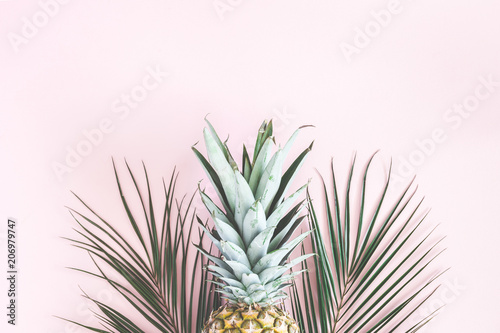 Pineapple and tropical palm leaves on pastel pink background. Summer concept. Flat lay, top view