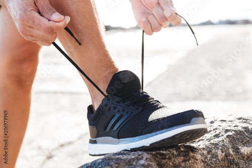 Close up of a man tying tying shoelace