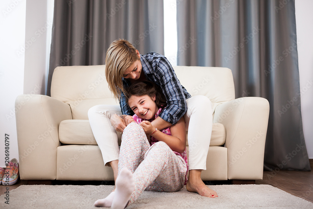Happy family of mother and daughter cuddling in the living room Happy family of mother and daughter cuddling in the living room