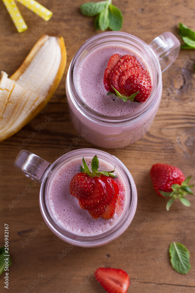 Milkshake with strawberries and banana. Strawberry smoothie. View from above, top studio shot Milkshake with strawberries and banana. Strawberry smoothie. View from above, top studio shot