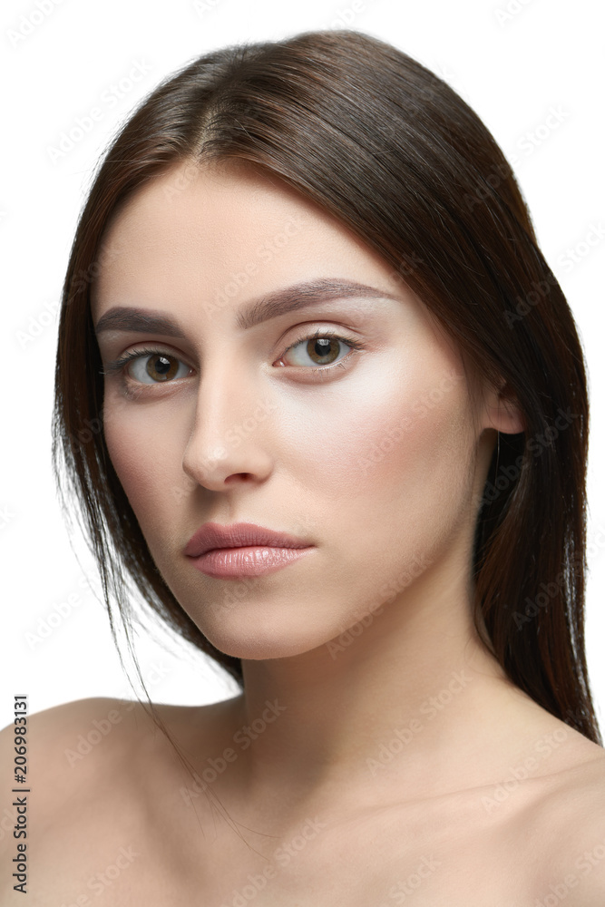 Close up of a girl with light day make up looking at camera. model having beatiful face with nice smile, plump lips, big eyes, white teeth. Dark brown hair, opened shoulders. White studio background. Close up of a girl with light day make up looking at camera. model having beatiful face with nice smile, plump lips, big eyes, white teeth. Dark brown hair, opened shoulders. White studio background.
