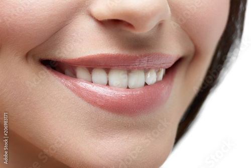 Studio close up of model's beatiful smile on white background. Healthy smooth skin, white teeth, plump rosy lips, little nose and dark brown hair on background. Beatiful smile.